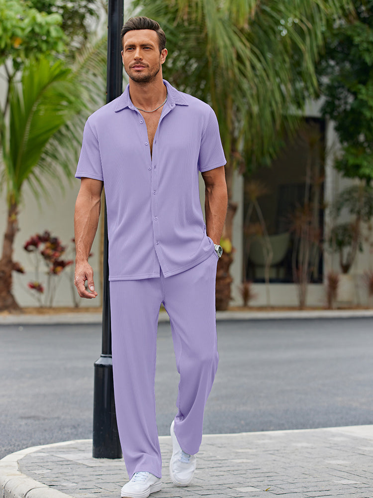 Model draagt het gestreepte herenoverhemd casual in bruin, gecombineerd met een lichte broek op het strand.