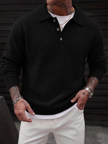 Model draagt de Mika gebreide polo trui in zwart, staand in een casual setting, toont de losse pasvorm.