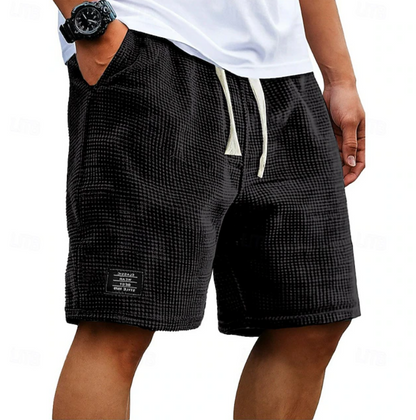 Detailopname van de trekkoord tailleband en de zakken van de grijze casual shorts.