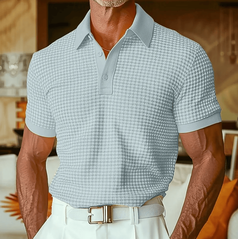Het Nils poloshirt, opgevouwen op een tafel, toont de nette afwerking en het kleurenpalet van het shirt.