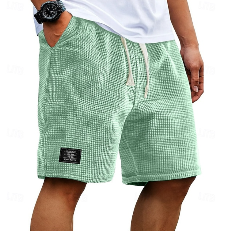 Achterkant van de beige wafelkatoenen shorts, met aandacht voor de relaxte pasvorm en de afwerking.