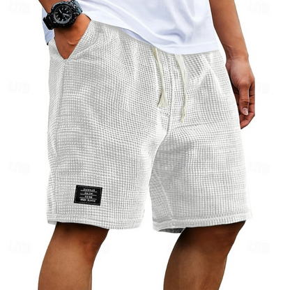 De Nils wafelkatoenen shorts in donkerbruin en wit, plat gelegd om de stof en het ontwerp te tonen.