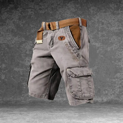 Model zit ontspannen en draagt de Noel cargoshorts in grijs, casual setting
