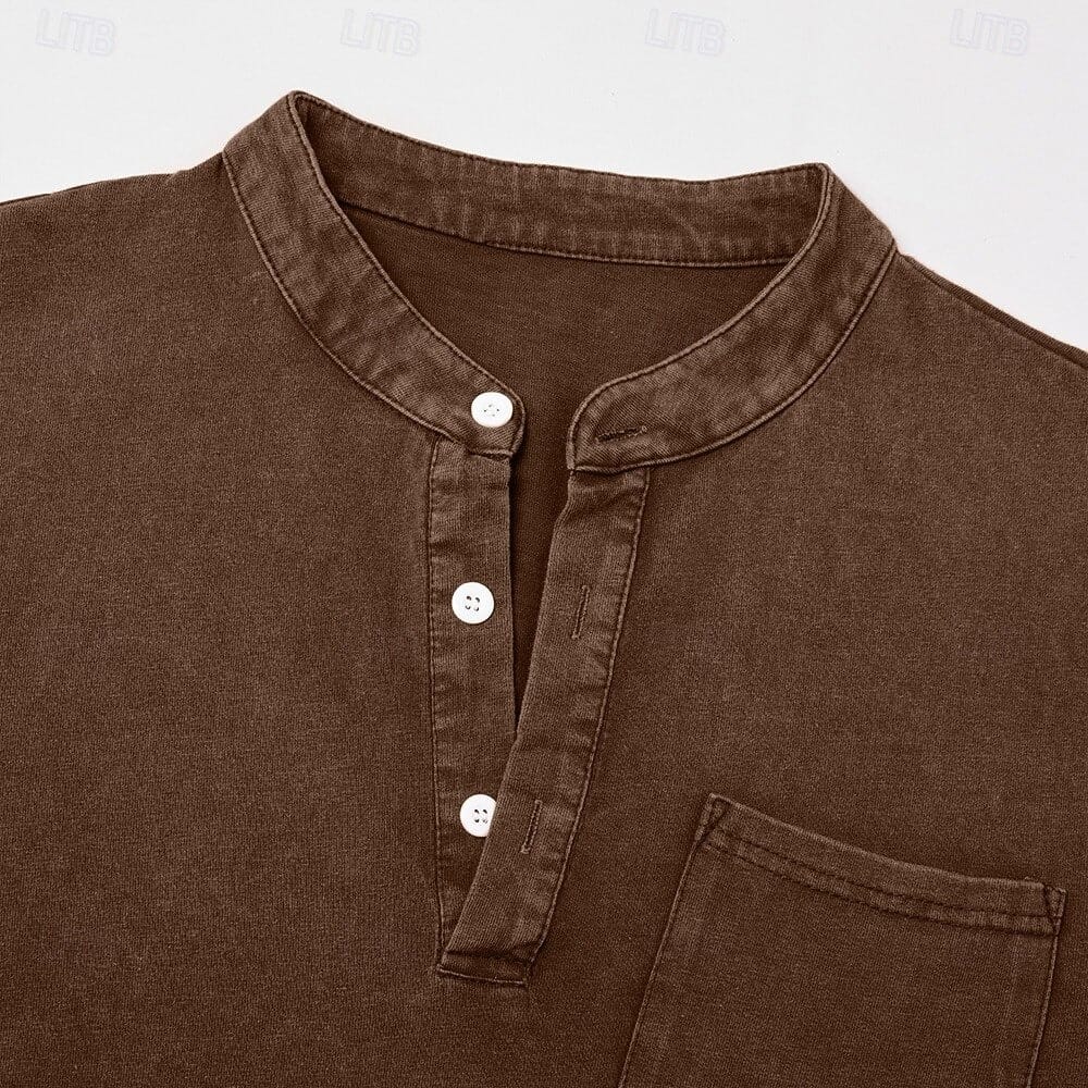 Model in het blauwe Henley shirt, lachend, wat het draagcomfort en de bewegingsvrijheid suggereert.