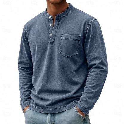 Model draagt het zwarte Henley shirt in een casual setting, benadrukt de veelzijdigheid.