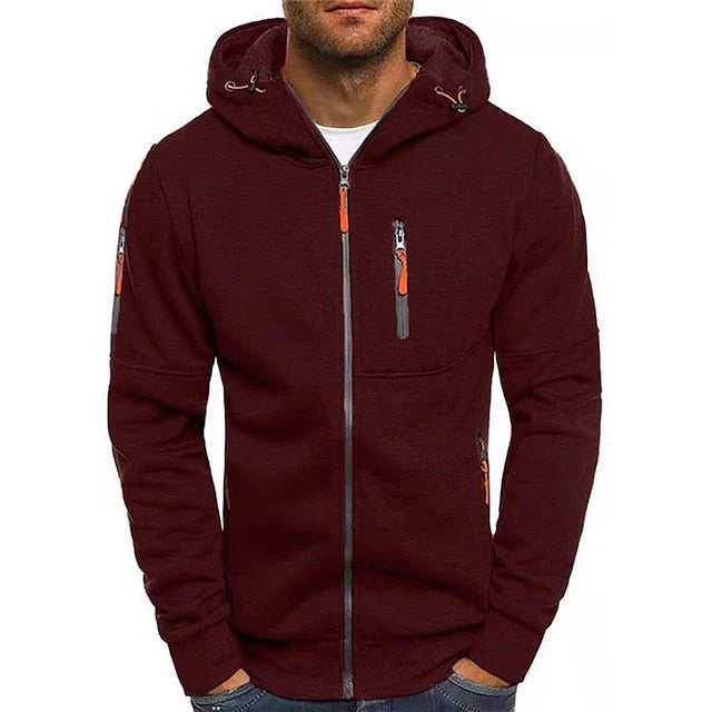 Een man in een zwarte Otto hoodie, zittend in een café, toont het gemak en de ongedwongen elegantie van de kleding.