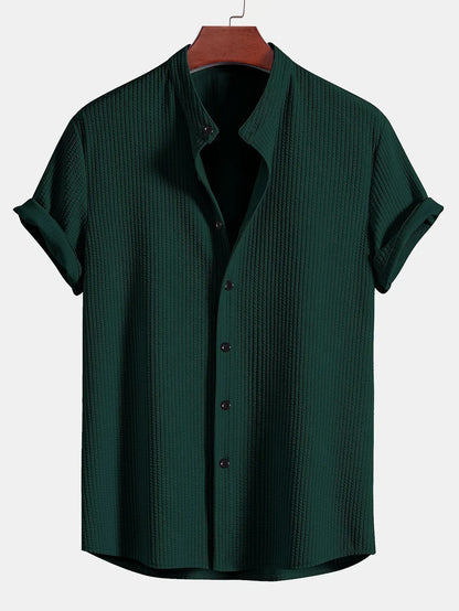 Model draagt het Peter premium heren overhemd in marineblauw, in een formelere setting, onder een blazer.