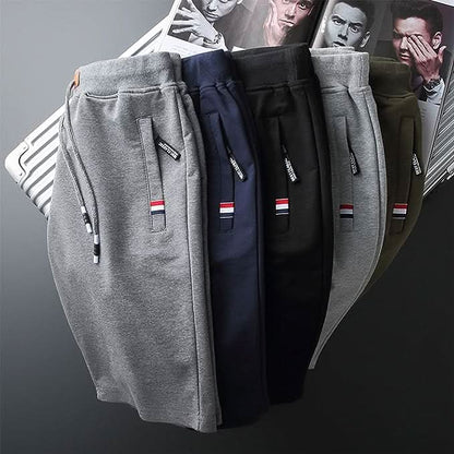 Quinn sportieve shorts in marineblauw, voorzijde, gedragen door een man in actieve pose, toont de pasvorm en stretch.