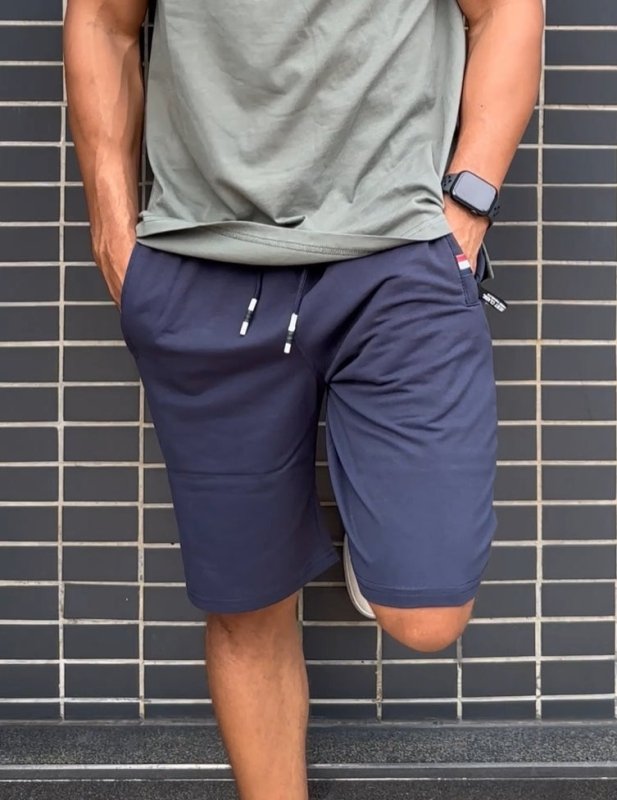 Zijaanzicht van de Quinn comfortabele shorts in het zwart, toont de praktische ritszakken en de moderne pasvorm.