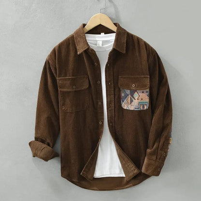 Een man draagt het creme-witte corduroy overshirt open over een T-shirt, casual en stijlvol voor dagelijks gebruik.