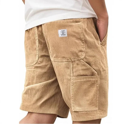 Man die de Remi comfortabele cargoshort in donkergroen draagt, zittend op een bankje, met focus op het comfort.