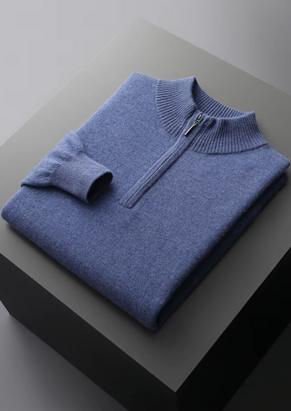 Detail van de mouwboord en zoom van de blauwe half-zip sweater, toont subtiele elasticiteit en afwerking.