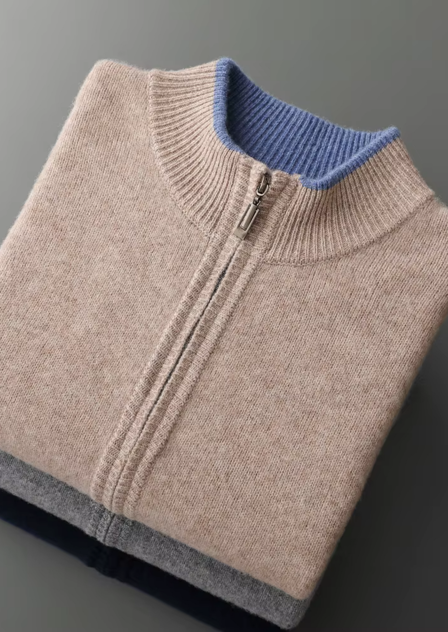 Close-up van de onderkant en de zoom van de donkerblauwe cardigan, nette afwerking.