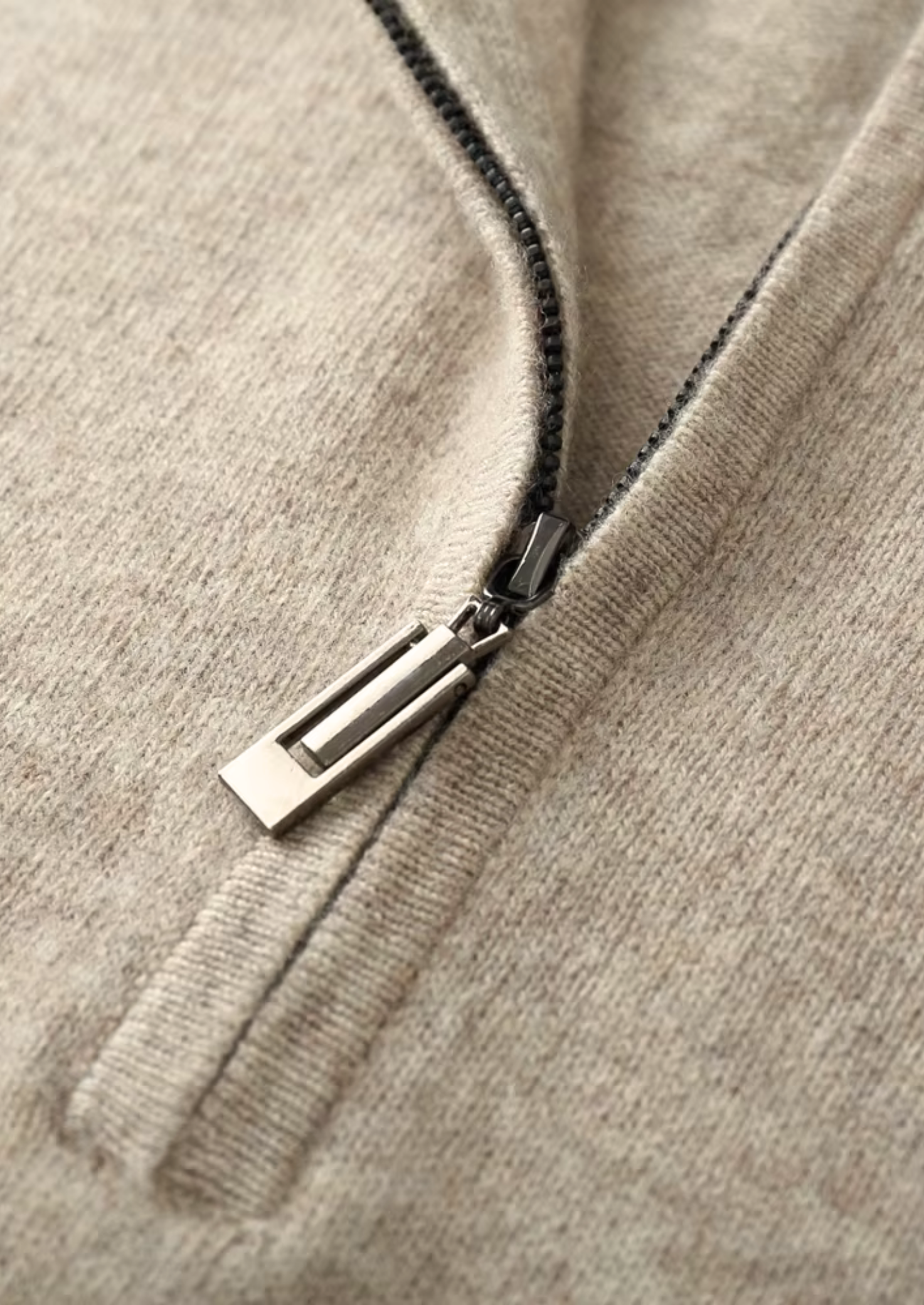 Textuurdetail van de extra-fijne merinowol van de blauwe sweater, toont de zachte stofkwaliteit.