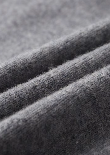 Close-up van de mouwboord en de naadloze afwerking van de beige cardigan.