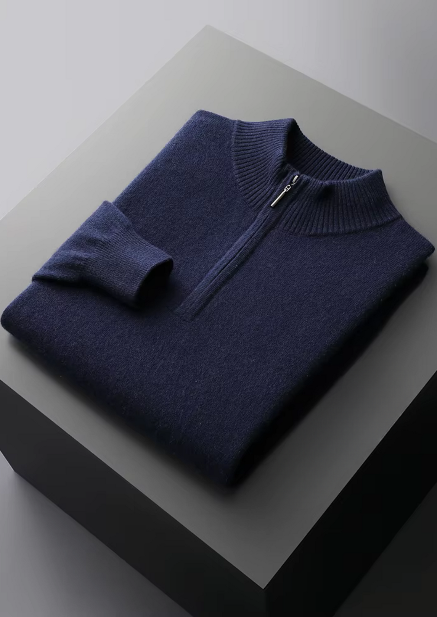 Opgevouwen marineblauwe merinowollen sweater, klaar om te dragen of mee te nemen voor onderweg.