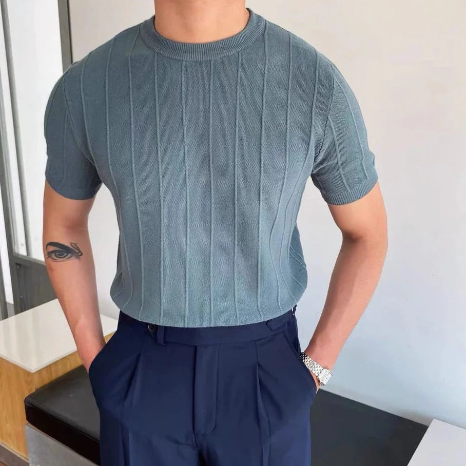 Man met een wit Reuben T-shirt, casual gestyled met een zonnebril en een ontspannen houding.
