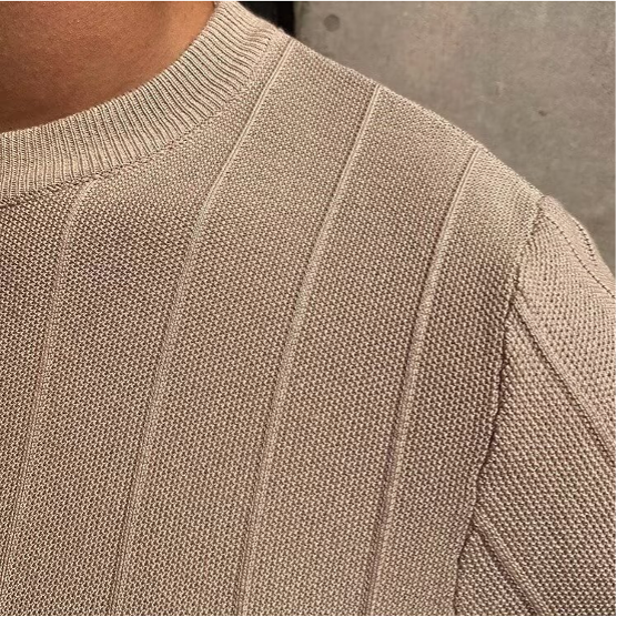 Een man draagt het beige Reuben T-shirt in een ontspannen setting, perfect voor de zomerse dagen.