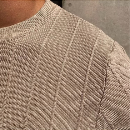Een man draagt het beige Reuben T-shirt in een ontspannen setting, perfect voor de zomerse dagen.