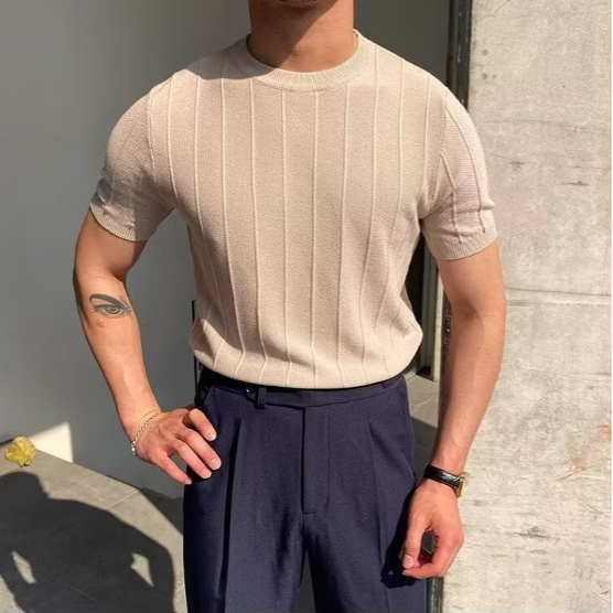 Zijaanzicht van de man in het beige Reuben T-shirt, wat de slim-fit pasvorm benadrukt.