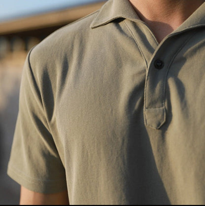 Een man gekleed in het Reuben heren poloshirt, staand in een ontspannen setting, toont de reguliere pasvorm.