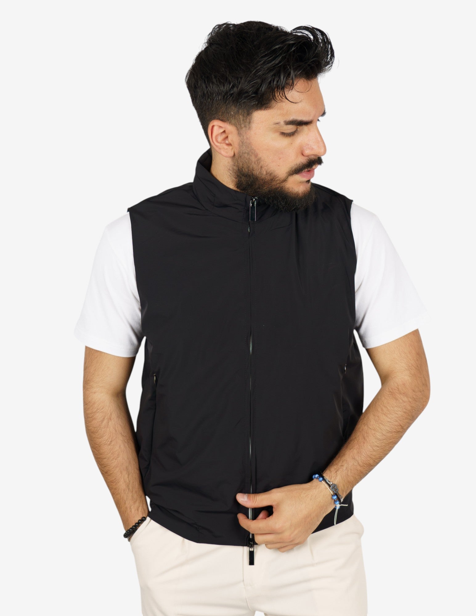 Een man draagt het veelzijdige vest over een wit T-shirt, casual gestyled voor een ontspannen look.
