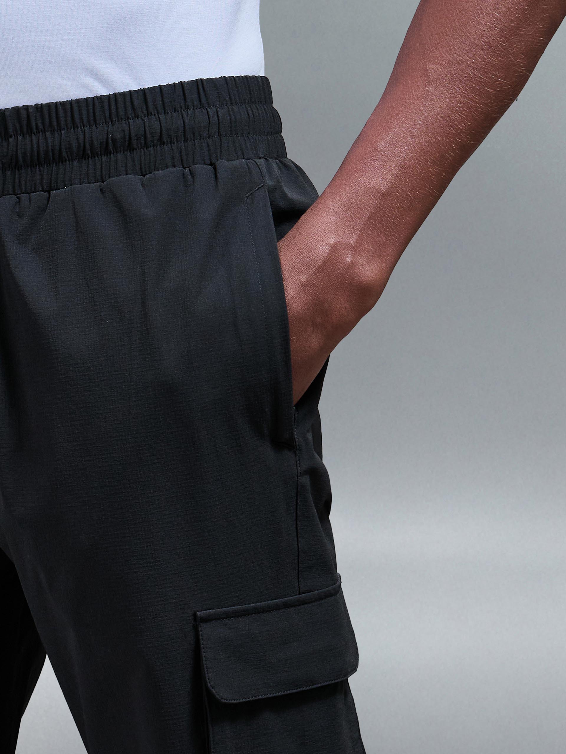 Close-up van de technische ripstop nylon stof van de heren cargo broek, die de textuur en stretchkwaliteit toont.
