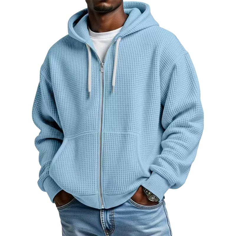 Vooraanzicht van de Gerrit wafeltextuur hoodie met rits in blauw, gedragen door een man in een ontspannen pose.