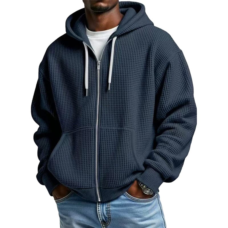 Zijaanzicht van de blauwe wafelgebreide hoodie, toont de ruime capuchon en de lengte van het kledingstuk.