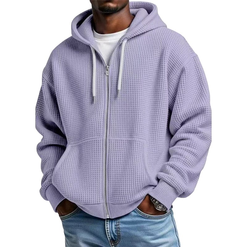De marineblauwe Gerrit hoodie, gedragen door een man die over een veld loopt, voor een actieve look.