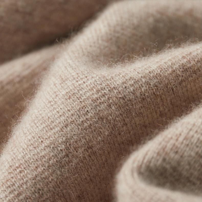 Een detail van de kraag van de marineblauwe Merino wollen trui, met de neklijn en de rits.