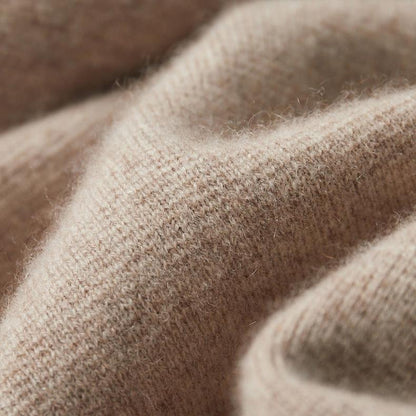 Een detail van de kraag van de marineblauwe Merino wollen trui, met de neklijn en de rits.